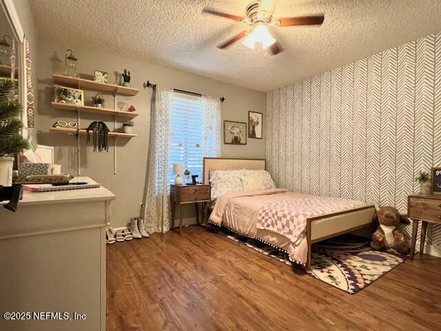 bedroom featuring a textured ceiling, ceiling fan, and dark hardwood / wood-style floors