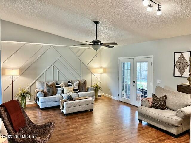 living room featuring french doors, a textured ceiling, ceiling fan, and dark wood-type flooring