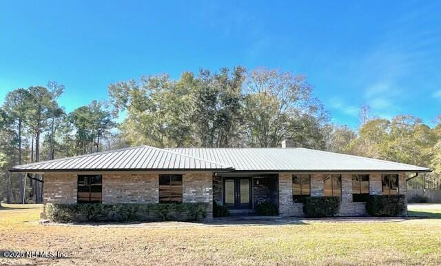 ranch-style home with french doors and a front lawn