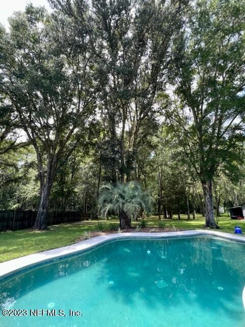 view of pool featuring a yard