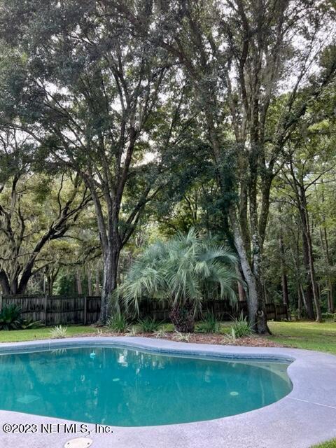 view of swimming pool featuring a lawn