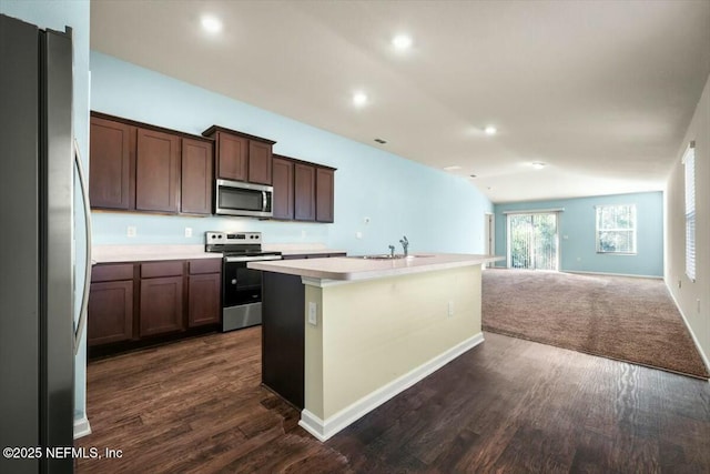 kitchen with dark hardwood / wood-style flooring, dark brown cabinetry, stainless steel appliances, and an island with sink