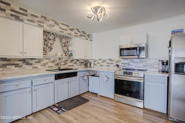 kitchen with decorative backsplash, appliances with stainless steel finishes, light stone counters, sink, and white cabinetry