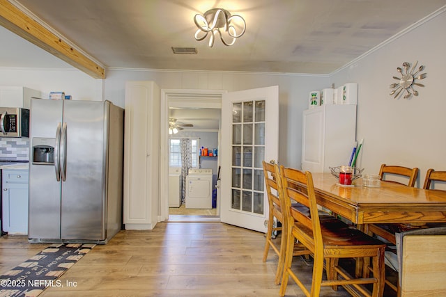 dining area featuring washer / dryer, ceiling fan with notable chandelier, light hardwood / wood-style floors, and crown molding