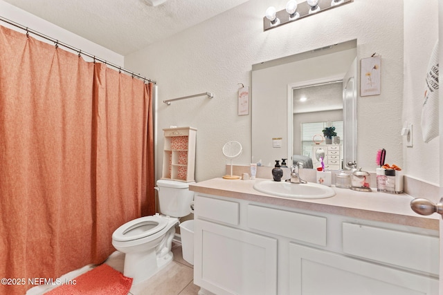 bathroom featuring tile patterned flooring, vanity, toilet, and a textured ceiling