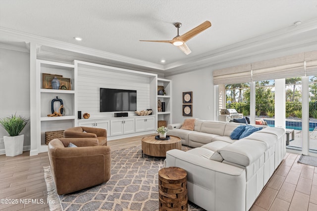 living room with ceiling fan, a textured ceiling, and ornamental molding