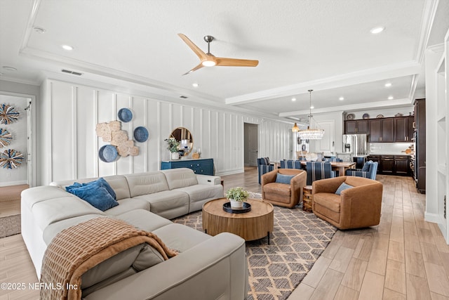 living room with ceiling fan, light hardwood / wood-style floors, and crown molding