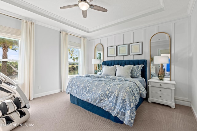 bedroom featuring ceiling fan, light colored carpet, crown molding, and a tray ceiling