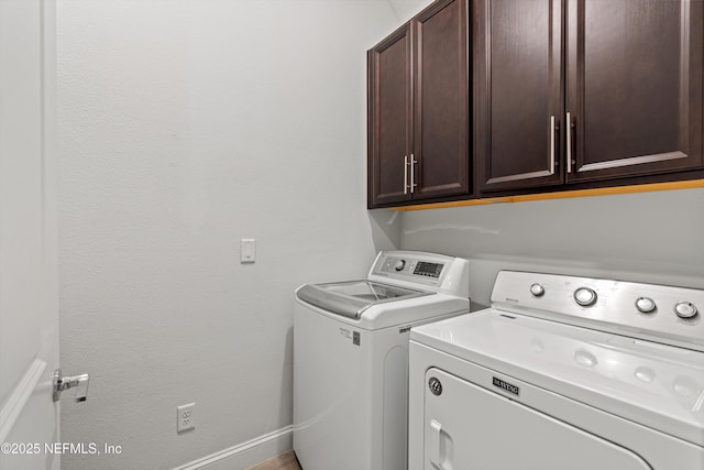 laundry room with washing machine and dryer and cabinets