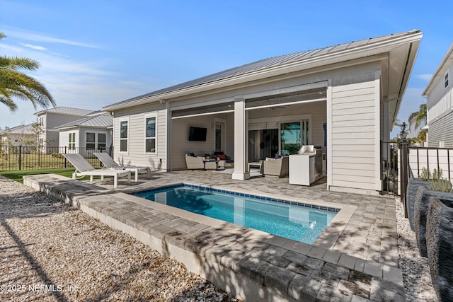 rear view of house featuring a patio area, a fenced in pool, and an outdoor living space