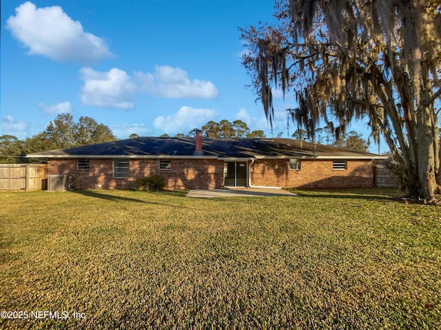 back of house featuring a lawn and a patio area