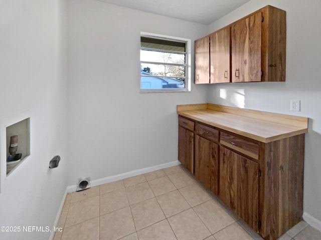 laundry area featuring cabinets, light tile patterned floors, and washer hookup