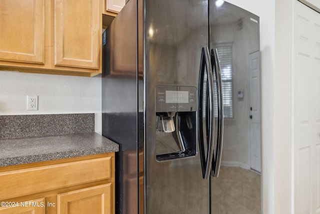 kitchen with black refrigerator with ice dispenser