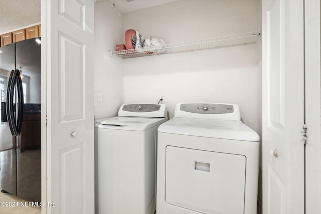 laundry area with light tile patterned floors and washing machine and clothes dryer