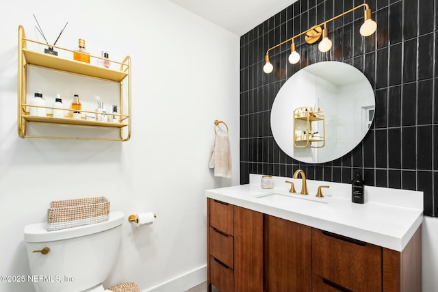 bathroom with vanity, backsplash, toilet, and tile walls