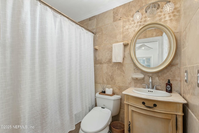 bathroom featuring vanity, tile walls, and toilet