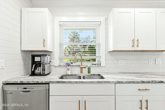 kitchen with dishwasher, light stone countertops, white cabinetry, and sink