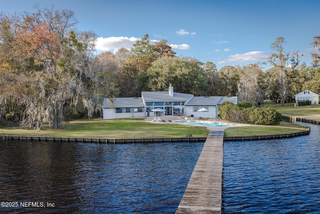 view of dock with a water view, a yard, and a patio