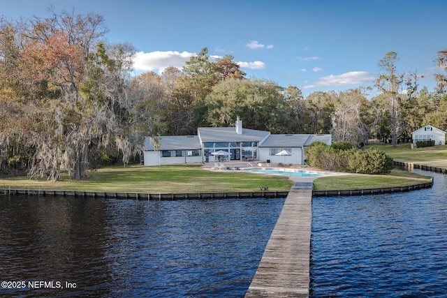 view of dock with a water view, a yard, and a patio