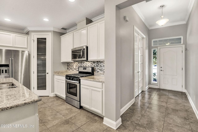 kitchen with light stone countertops, white cabinetry, and appliances with stainless steel finishes