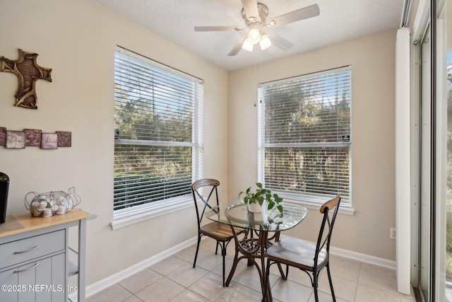 tiled dining room featuring ceiling fan and plenty of natural light