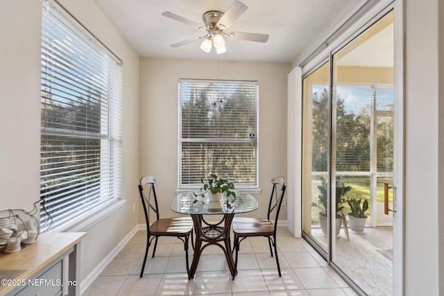 tiled dining space with a textured ceiling and ceiling fan