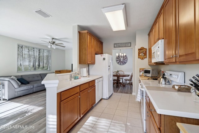 kitchen with ceiling fan, sink, kitchen peninsula, white appliances, and light tile patterned floors