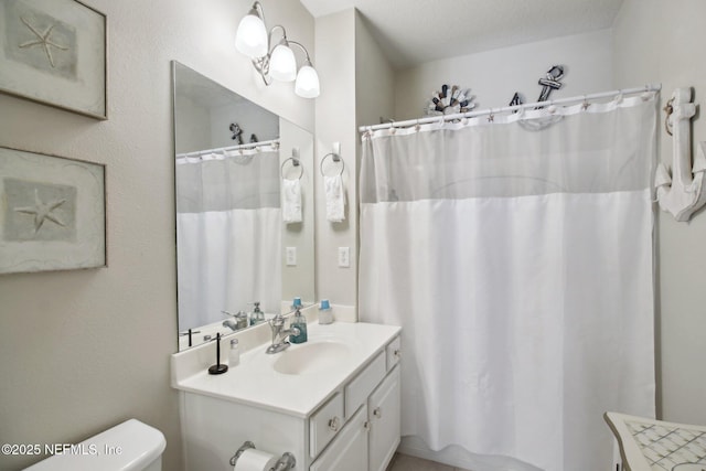 bathroom with a shower with shower curtain, vanity, toilet, and a textured ceiling