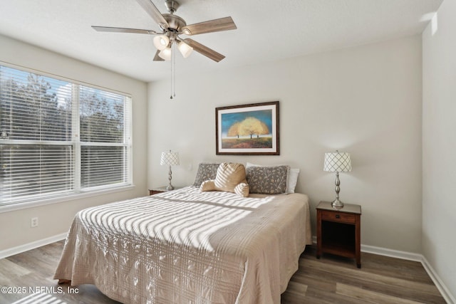 bedroom with dark hardwood / wood-style floors and ceiling fan