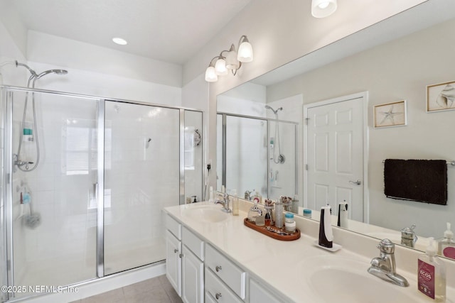 bathroom featuring tile patterned flooring, vanity, and a shower with door