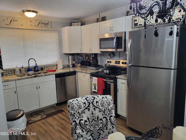 kitchen with light stone countertops, white cabinetry, sink, and appliances with stainless steel finishes