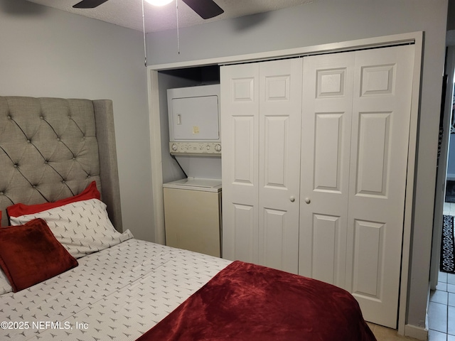 bedroom with a closet, a textured ceiling, stacked washer and dryer, and ceiling fan