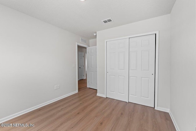 unfurnished bedroom with light hardwood / wood-style floors and a closet