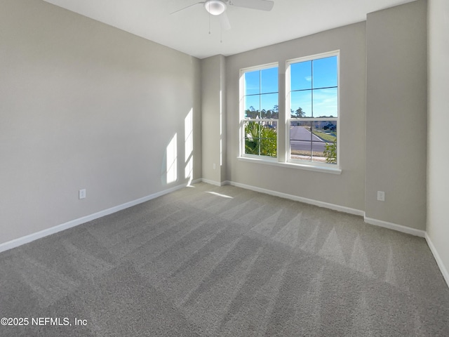 carpeted spare room featuring ceiling fan