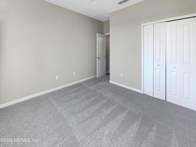 unfurnished bedroom with carpet flooring, ceiling fan, and a closet