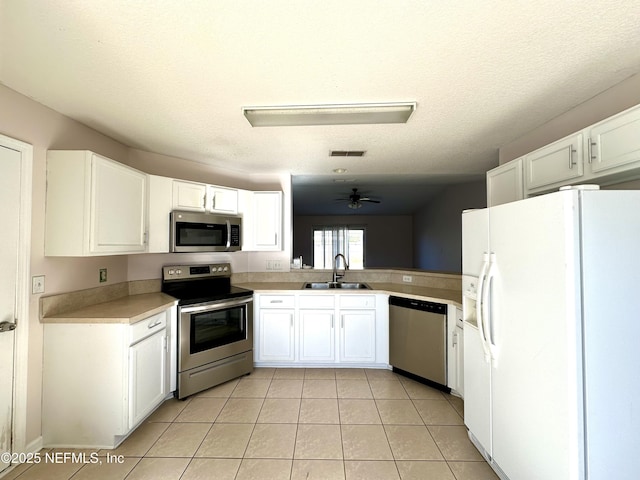 kitchen with white cabinets, sink, ceiling fan, light tile patterned floors, and stainless steel appliances