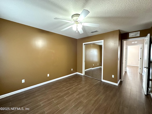 unfurnished bedroom featuring ceiling fan, a closet, and dark wood-type flooring