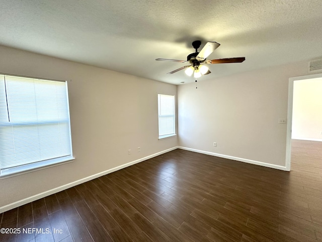 spare room featuring a textured ceiling, ceiling fan, and dark wood-type flooring