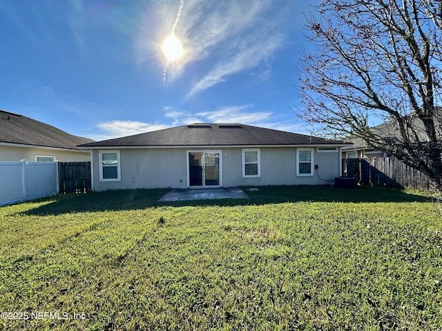 rear view of property featuring a lawn and a patio