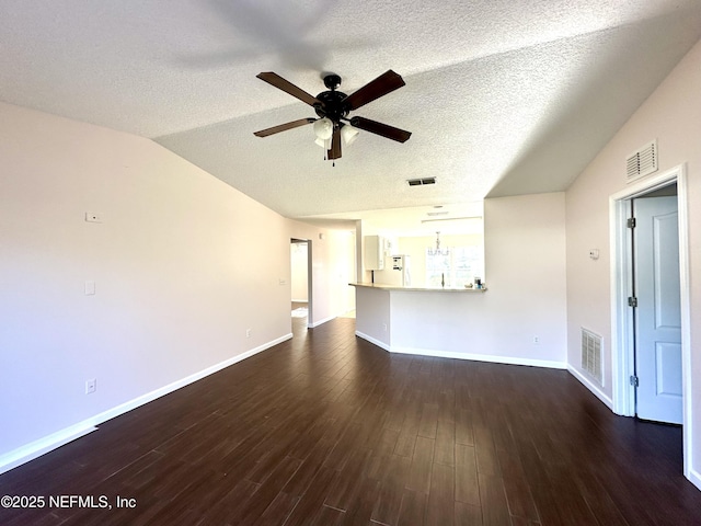 unfurnished living room with a textured ceiling, ceiling fan, dark hardwood / wood-style flooring, and vaulted ceiling