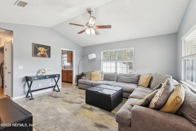 living room with ceiling fan, sink, and vaulted ceiling