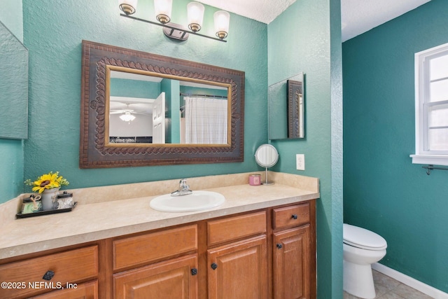 bathroom featuring tile patterned floors, ceiling fan, vanity, and toilet