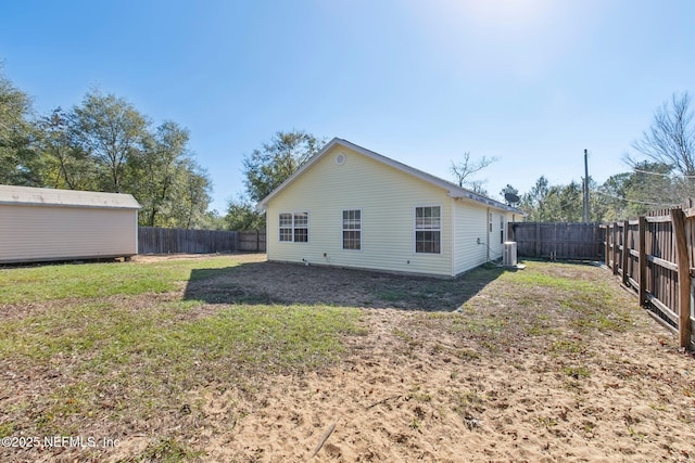 back of house with a yard and central AC