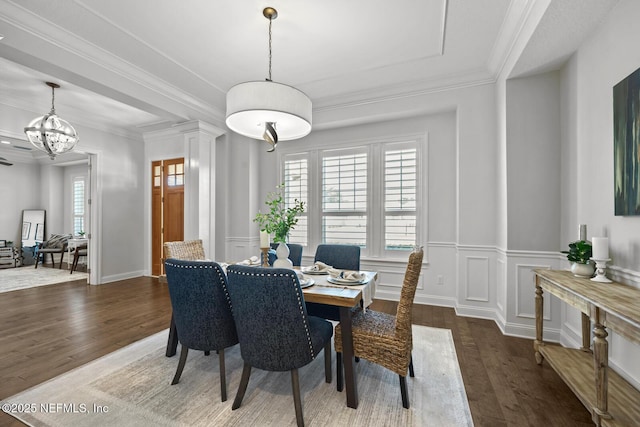 dining room featuring crown molding, dark hardwood / wood-style flooring, and an inviting chandelier