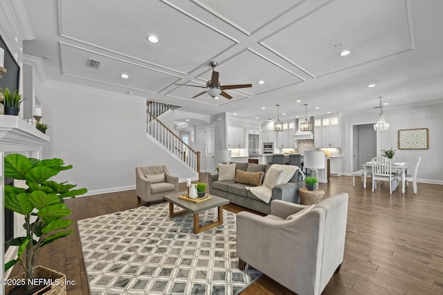 living room with dark hardwood / wood-style floors, ceiling fan, crown molding, and coffered ceiling