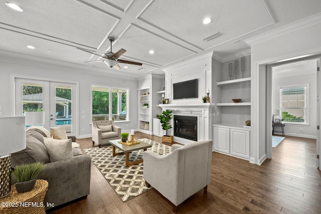 living room with coffered ceiling, built in shelves, ceiling fan, dark hardwood / wood-style floors, and a textured ceiling