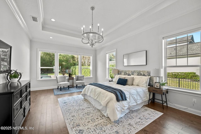 bedroom with dark hardwood / wood-style flooring, a raised ceiling, and multiple windows