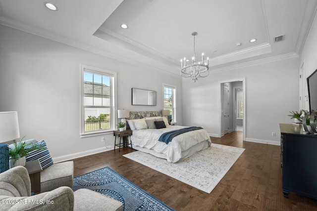 bedroom featuring a tray ceiling, crown molding, dark wood-type flooring, and an inviting chandelier