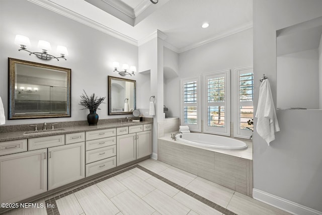 bathroom with tile patterned floors, crown molding, vanity, and a relaxing tiled tub