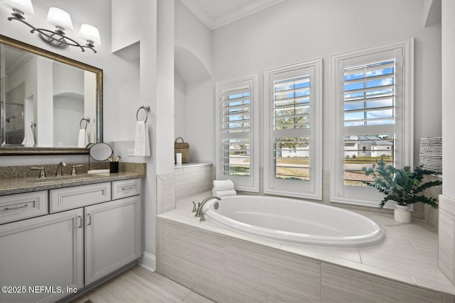 bathroom with vanity and a relaxing tiled tub